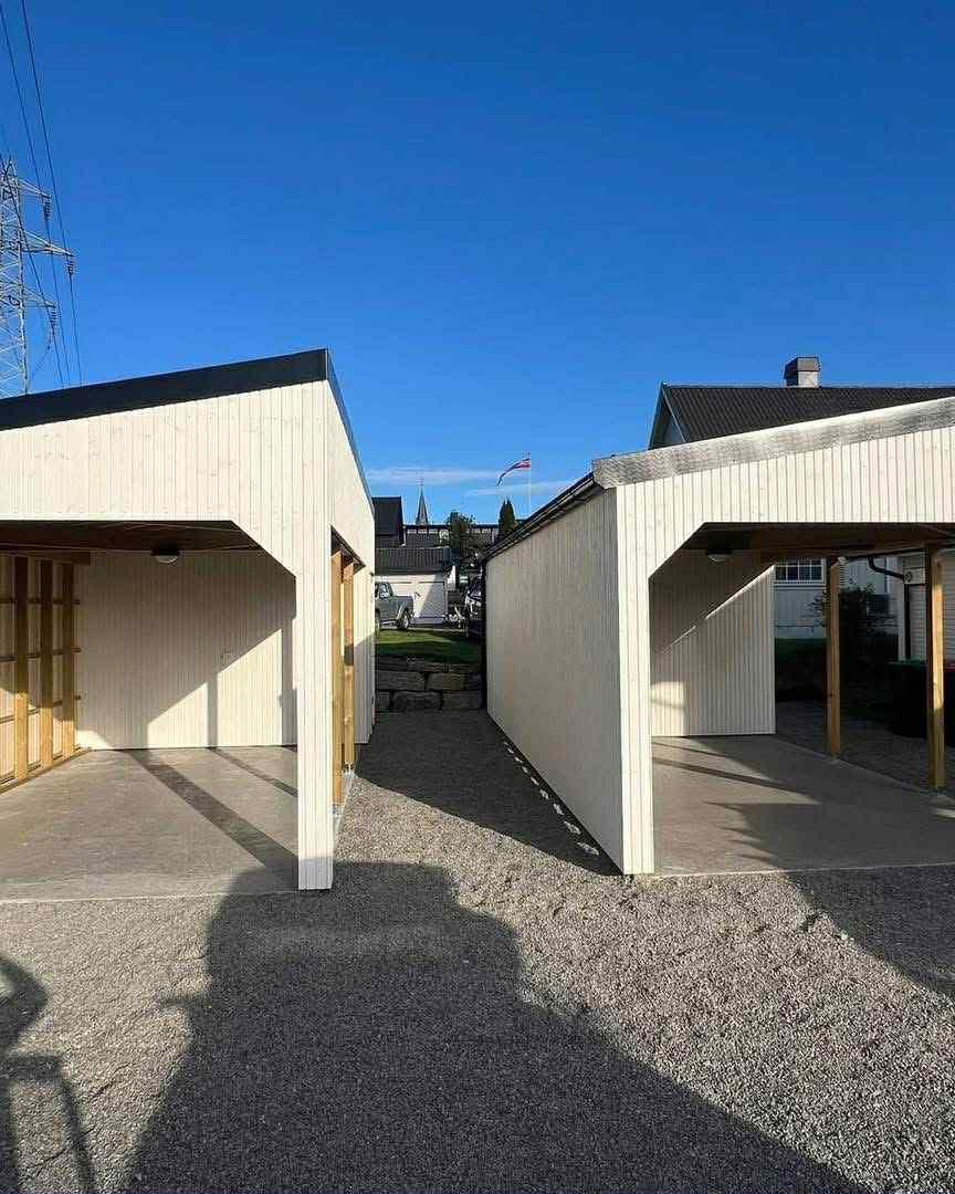 To like carporter med hvite stolper og mørkt tak, foran et hus
